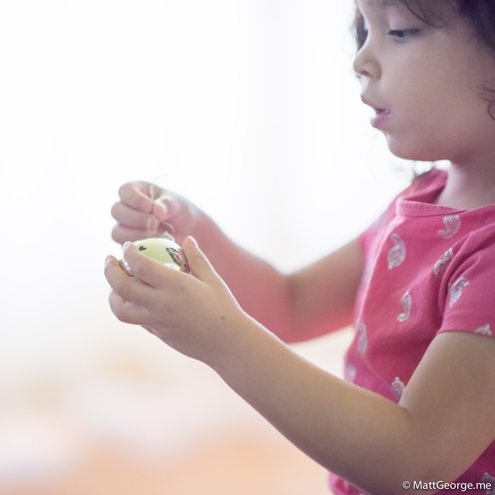Bella Holding the Silver Christmas Ornament
