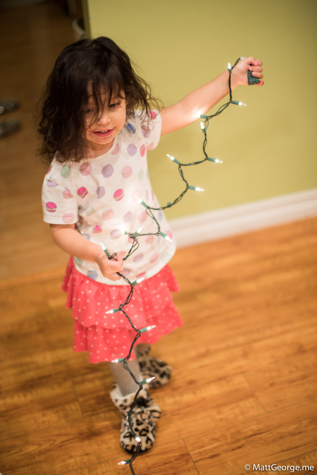 Bella Holding a String of White Christmas Light