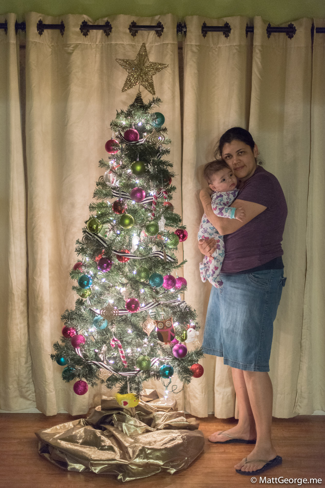 Eugenia Holding Baby Gianna Near Christmas Tree